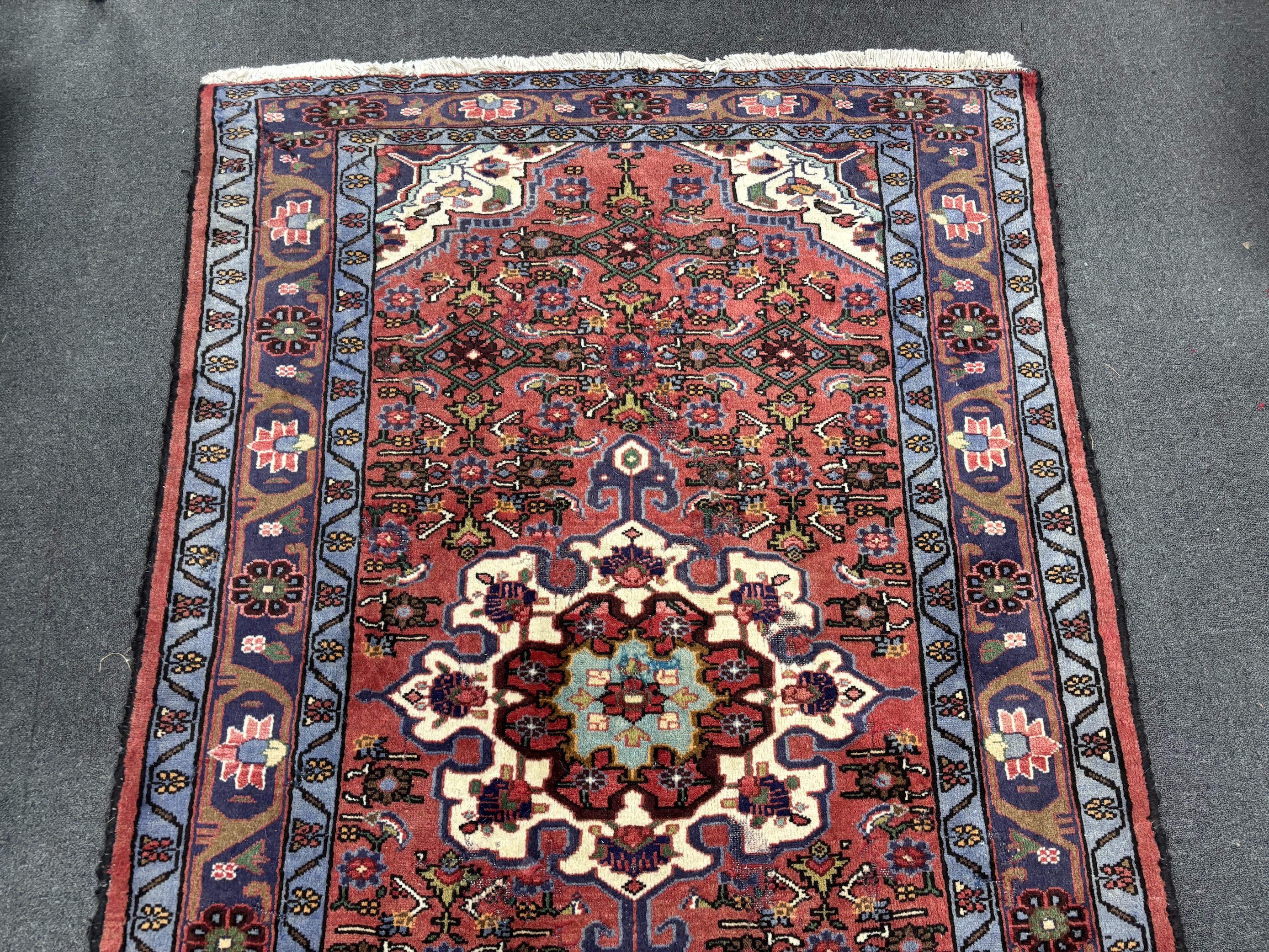 A Caucasian red ground rug, 206 x 130cm